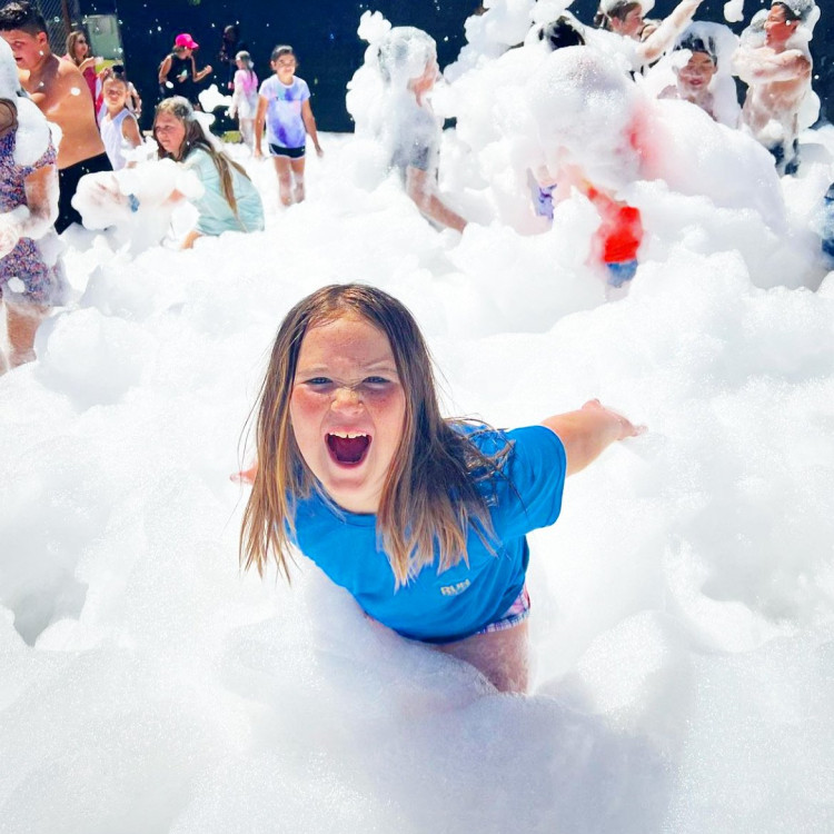 Foam machine rental party with kids playing in foam at a backyard
