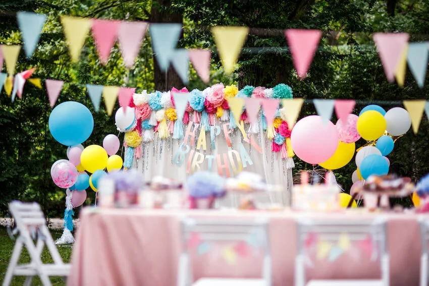 Colorful summer party themes decorations with balloons and banner in a backyard