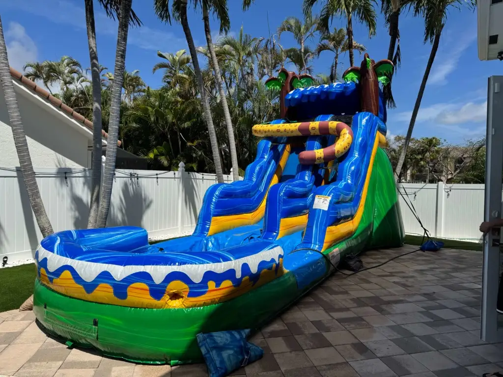 Professional water slide setup in a Bay Area backyard with kids sliding down